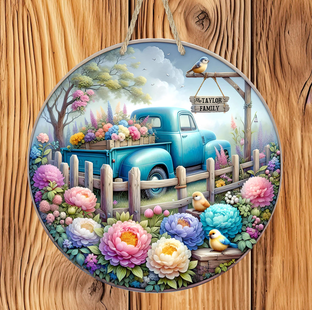 Personalized spring 14 inch round sign featuring a vintage blue truck filled with colorful flowers  surrounded by garden blooms and songbirds with a rustic hanging nameplate - Personalized Kreation